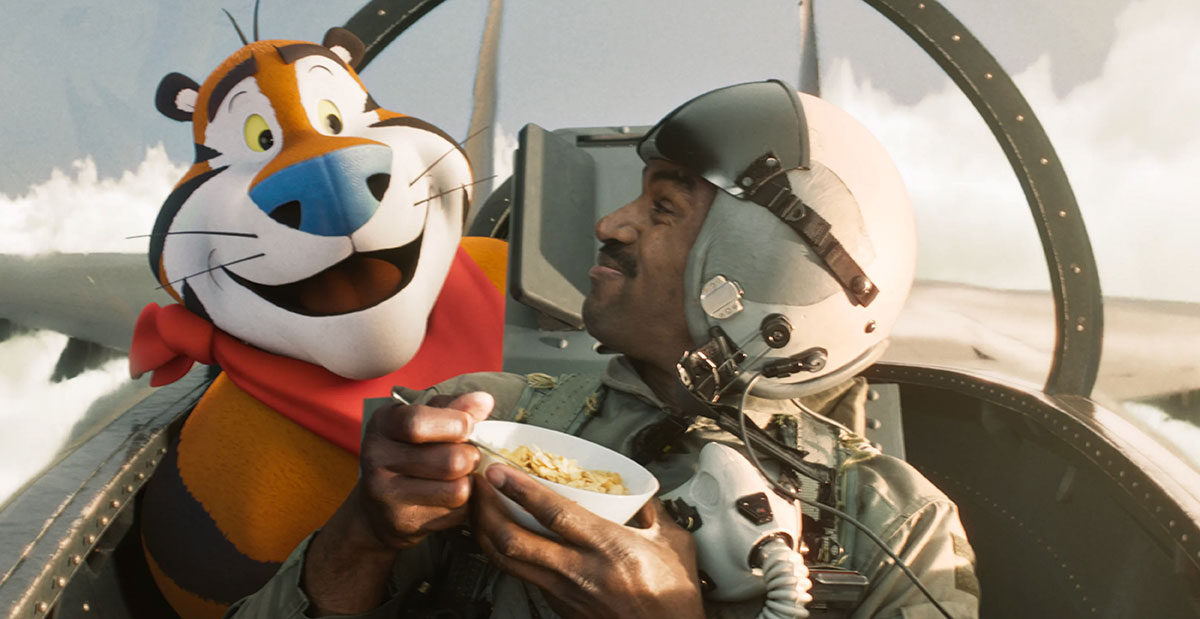 Tony the Tiger sitting in a fighter jet cockpit beside a pilot eating a bowl of Frosted Flakes