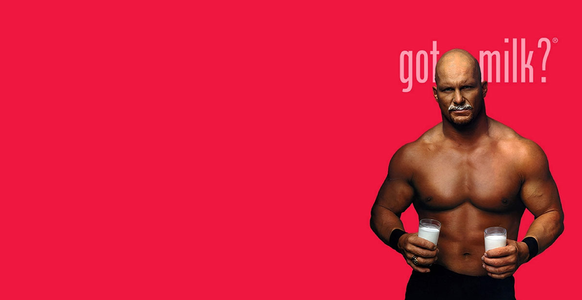 Got Milk print ad with Stone Cold Steve Austin wearing a milk mustache and holding two glasses of milk on a red background