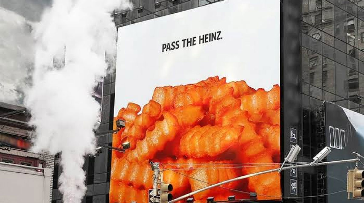 Heinz billboard on a city building showing crinkle-cut fries under the headline Pass the Heinz